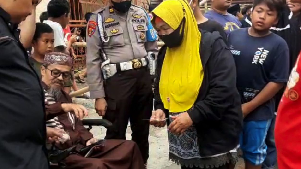 Viral Pria Tua Berkursi Roda Bagi Uang ke Ribuan Warga di Makassar, Siapa Dia?