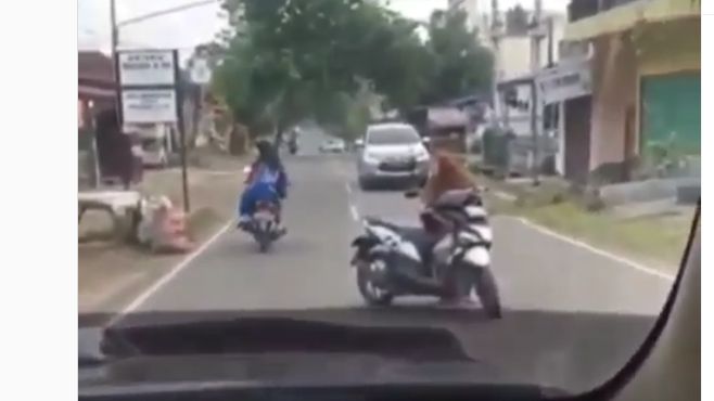 Viral! Emak-emak Ngobrol Santuy di Tengah Jalan Raya Sambil Menuntun Motor