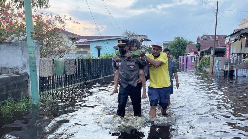 Gigihnya Polisi Ini Selamatkan Nenek yang Kebanjiran di Riau, Sampai Digendong