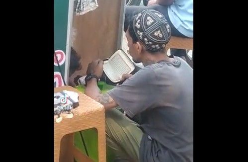 Mengaji Sembari Bersembunyi di Belakang Gerobak Jualannya, Pria Ini Bikin Warganet Iri