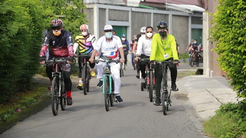 Mirip Jokowi, Intip Gaya Gibran Sapa Warga Solo Pakai Sepeda Lipat dan Bagi-bagi Buku